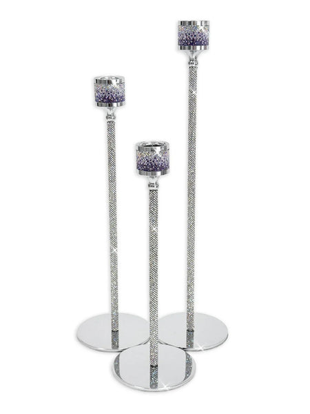 Three silver glitter candlestick holders of different heights with round mirrored bases and purple glitter candle cups, shown on a white background.