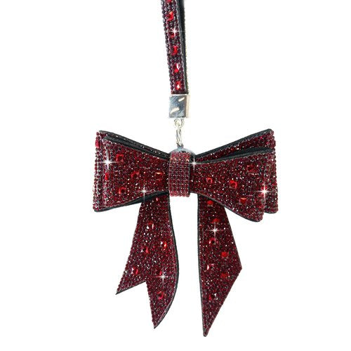 a bow shaped purse charm or keychain with dark red crystals embedded 